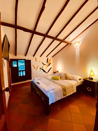 a bedroom with a large bed in a room at Hostal Casa Ceiba in Barichara