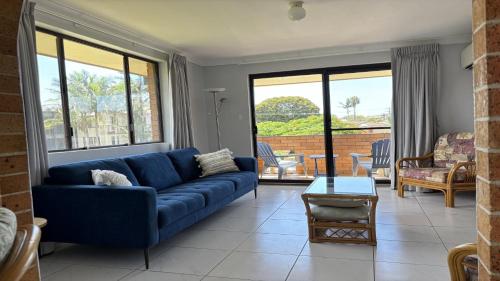 a living room with a blue couch and a table at 3/17 Park Street in Port Macquarie