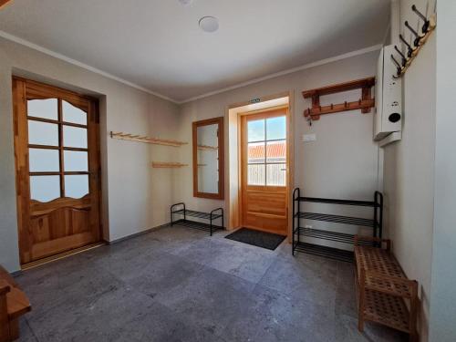 an empty room with a wooden door and windows at ZELTA KROGS in Brekti