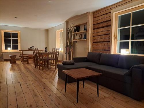 a living room with a couch and a table at ZELTA KROGS in Brekti