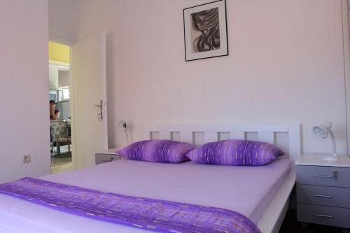 - un lit avec 2 oreillers violets dans l'établissement Apartment Karla 4, à Supetar