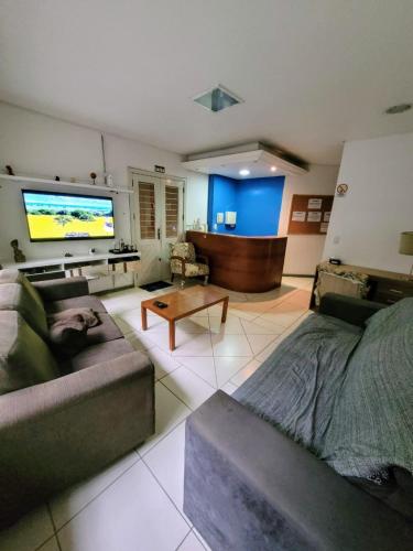 uma sala de estar com um sofá e uma televisão de ecrã plano em Man's Place Hostel Masculino em Porto Alegre