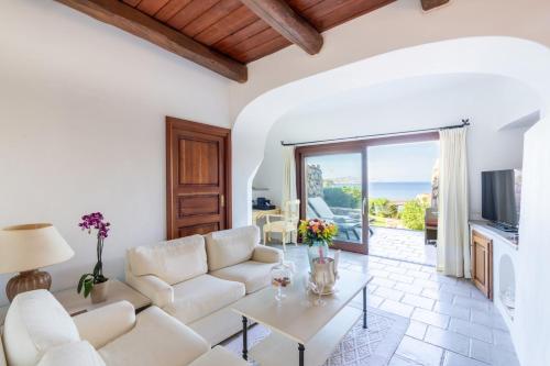 un soggiorno con divano e tavolo di Hotel Pitrizza, Costa Smeralda a Porto Cervo