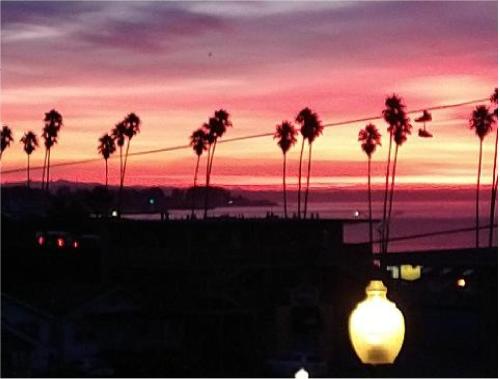 a sunset with a bunch of palm trees and a street light at Howard Johnson by Wyndham Santa Cruz in Santa Cruz
