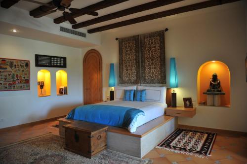 a bedroom with a bed with blue sheets and blue pillows at Lazib Inn Resort & Spa in Tunis