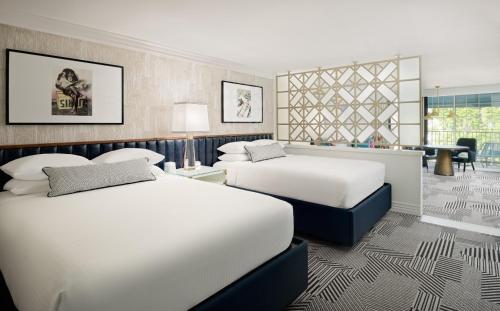 a hotel room with two beds and a desk at Le Parc at Melrose in Los Angeles