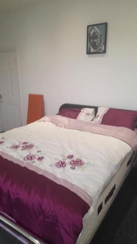a bed with a purple and white blanket on it at ACCANE in Sunderland