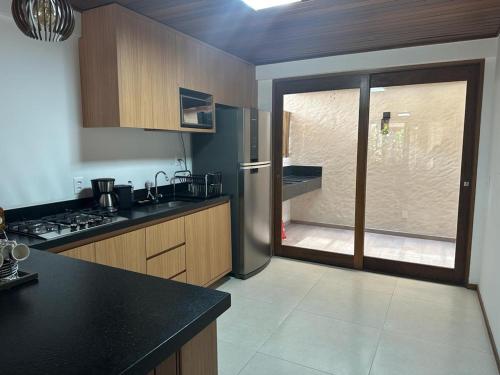 uma cozinha com um frigorífico de aço inoxidável e uma janela em Villa Andorinha, Apt 03 em Mucugê