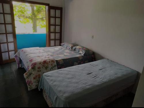 2 letti in una camera con finestra di Casa para temporada - Guarujá - Praia Pernambuco a Guarujá