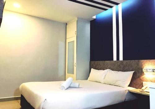 a bedroom with a bed with a white pillow on it at Mozu Hotel Sri Hartamas in Kuala Lumpur