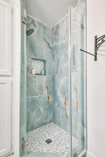 a bathroom with a shower with a glass door at Baca Beach Escape II in Galveston