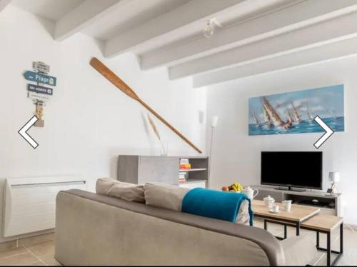 un salon avec un canapé et une télévision dans l'établissement Maison Ker Suliac, à Saint-Suliac