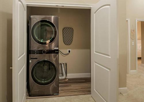 a washer and dryer in a room next to a door at Beach Bliss - 5 MIN WALK to BEACH - Family Retreat in Daytona Beach Shores
