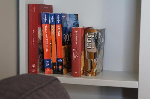 a row of books sitting on a shelf at SUITE Home Ladispoli in Ladispoli