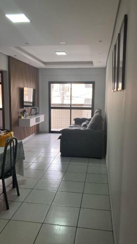 a living room with a bed and a large window at Apartamento praia Aviação in Praia Grande
