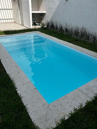 a swimming pool in the grass next to a house at Departamento con alberca y playa cerca Veracruz Rock in Boca del Río