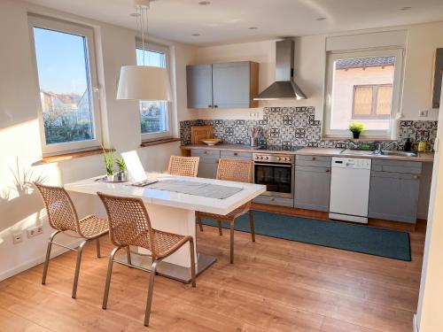 a kitchen with a table and chairs in a kitchen at Helle und gemütliche Ferienwohnung in Lorsch in Lorsch