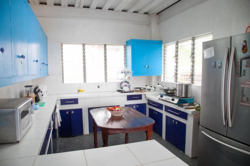 a kitchen with blue cabinets and a table in it at Villa Elena Guimaras in Buenavista
