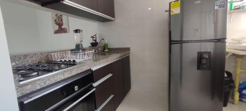 a kitchen with a stainless steel refrigerator and a stove at Privado y fascinante Apartaestudio San Alonso in Bucaramanga
