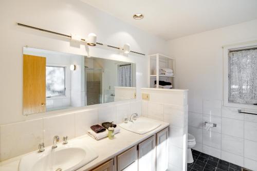 een witte badkamer met 2 wastafels en een spiegel bij Great Barrington Getaway Lake Access, Water Views in Great Barrington