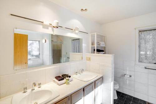 a white bathroom with two sinks and a mirror at Great Barrington Getaway Lake Access, Water Views in Great Barrington