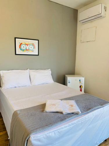 una camera da letto con un grande letto con lenzuola bianche di Pousada Sol & Mar a Serra