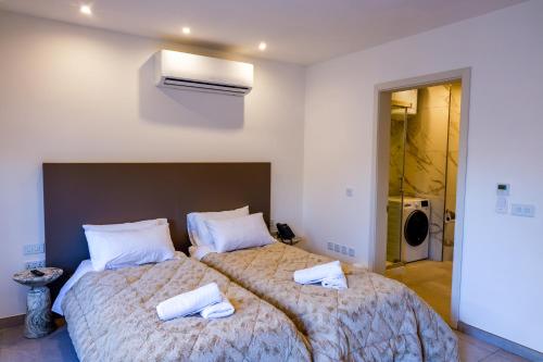 a bedroom with a large bed with towels on it at The Central guesthouse in Tal-Pietà