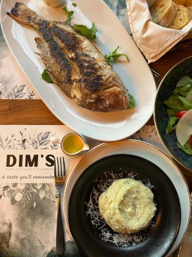 a table topped with two plates of food with fish at Dim's Hotel & Restaurant in Korçë
