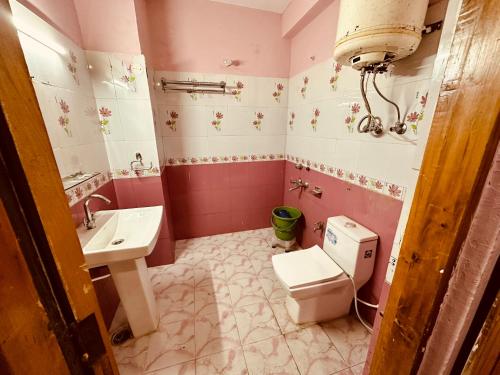 a bathroom with a toilet and a sink at WooibHotels The Daulat Manali in Manāli