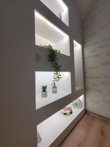una habitación con estanterías blancas con macetas. en Sleep and travel, en Sarajevo