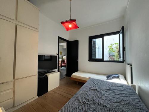 a bedroom with a bed and a tv and a window at Departamento temporal para 4 personas in Mar del Plata