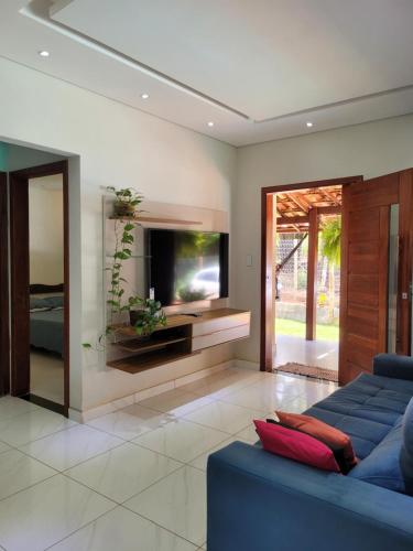 a living room with a blue couch and a tv at Casa do Fábio in Santana do Riacho