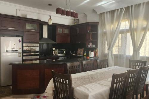 a kitchen with a table with chairs and a counter top at 3 bedroom apt excellent location near to malls in Cairo