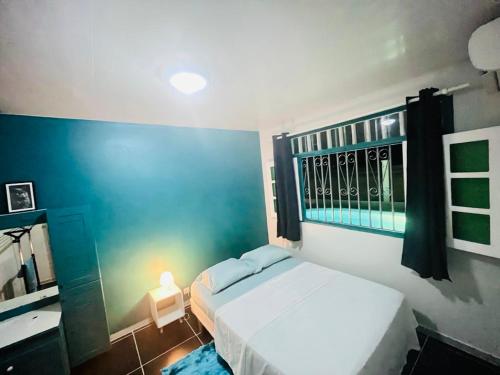 een slaapkamer met een wit bed en een raam bij Sermie T2 climatisé avec piscine in Kourou
