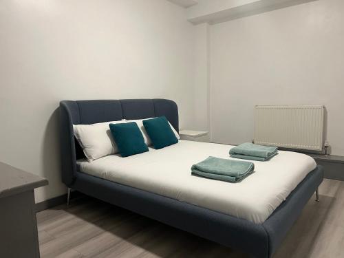 a bed with three pillows on it in a room at En-suite room in Swansea