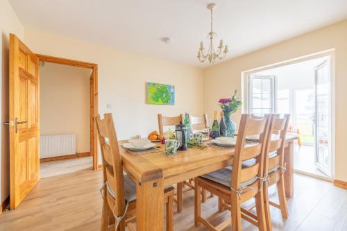 a dining room with a wooden table and chairs at The Ferns-Ideal base for exploring the Causeway Coast in Armoy