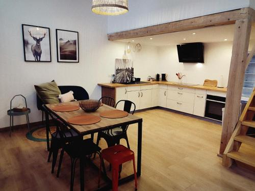 cocina y comedor con mesa y sillas en Le chaleureux loft 1 minute du tram, en Lingolsheim