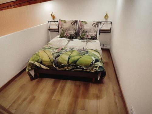 Le chaleureux loft 1 minute du tram في لينغولسهايم: سرير في غرفة صغيرة مع أرضية خشبية