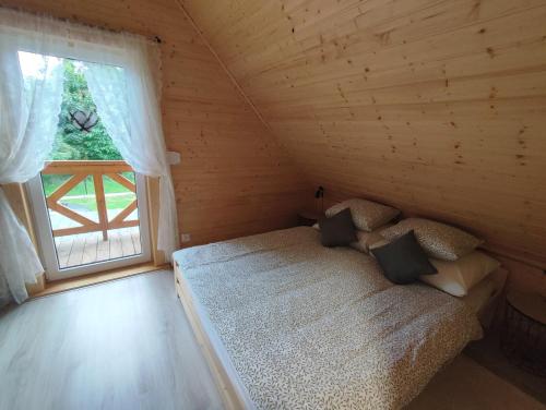 niewielka sypialnia z łóżkiem i oknem w obiekcie Smrekowa Chatka w Milówce w Milówce