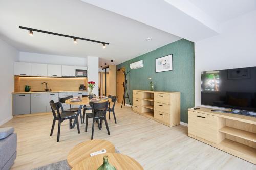 uma cozinha e sala de estar com mesa e cadeiras em EveRest Apartamenty Szczyrk em Szczyrk