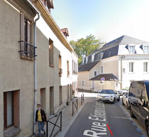 a man walking down a street next to a building at F2 4 pers 2lits proche 5 min aéroport Orly Chez Sandro et Abby in Athis-Mons