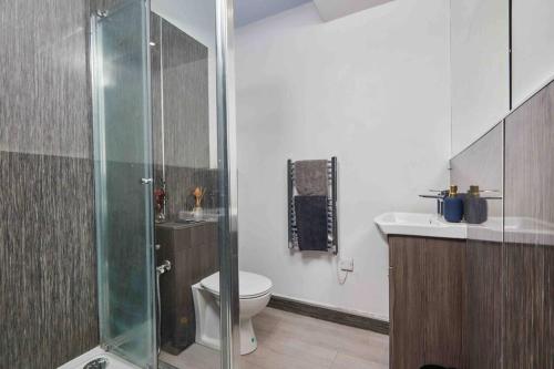 a bathroom with a toilet and a glass shower at 3 Beds - Perfect for Family & Work Relocations in Leeds