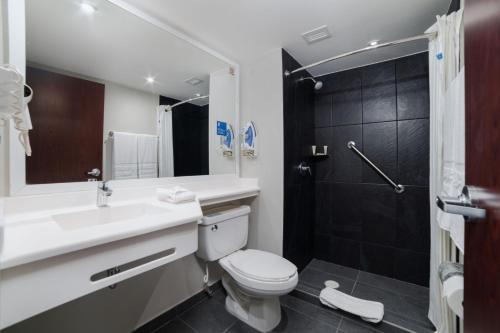 uma casa de banho com um WC, um lavatório e um chuveiro em City Express by Marriott Silao Aeropuerto em Silao