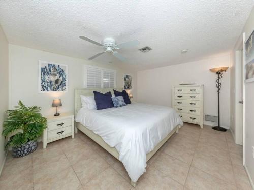 Un dormitorio con una cama y un ventilador de techo. en Alligator Escape - Heated pool haven just minutes from Venice beaches, en Venice
