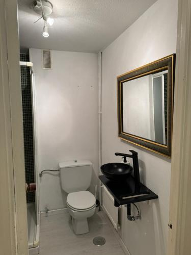 uma pequena casa de banho com WC e espelho em Loft Azom em Vigo