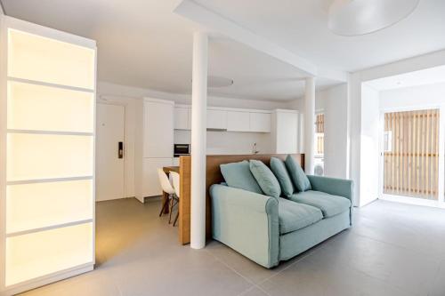 a living room with a blue couch and a kitchen at Historic Town Cascais Modern Apartment in Cascais
