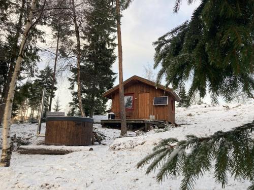Cabaña de madera pequeña con árboles en la nieve en Typisk norsk off-grid hytte opplevelse, en Levanger