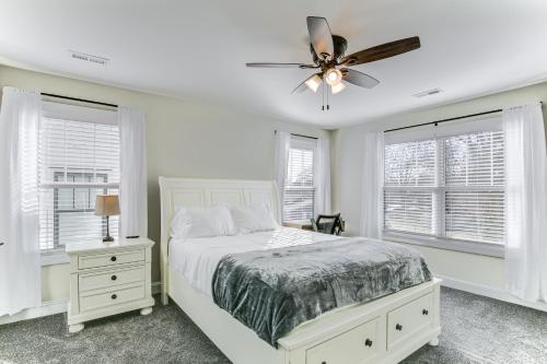 a white bedroom with a bed and a ceiling fan at Modern Greer Retreat Walk to Historic Downtown! in Greer