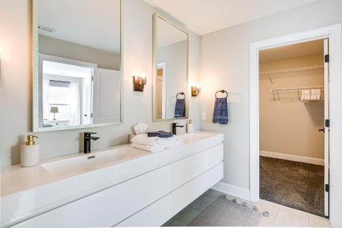 Baño blanco con lavabo y espejo en Modern Greer Retreat Walk to Historic Downtown! en Greer