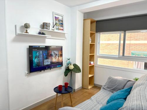 sala de estar con TV de pantalla plana en la pared en Apartamento Vialia en Málaga